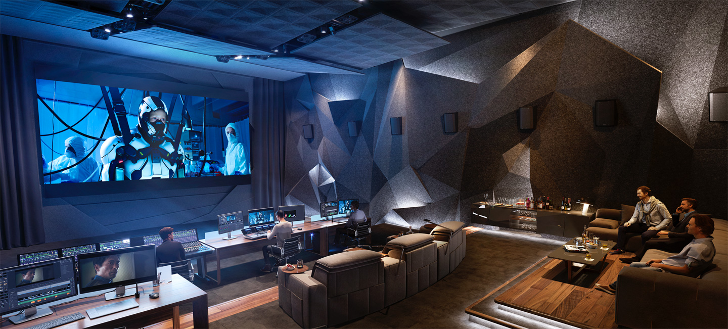 A very expensive looking cinema edit suite with multiple edit stations, viewing couches and huge cinema wall at the front.